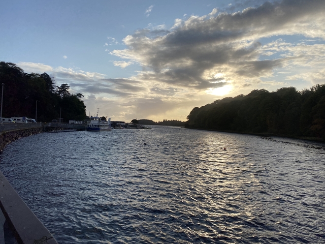       River with boats against a backdrop of a cloudy sky.
  