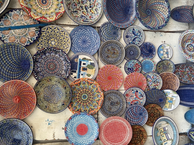       Colorful display of intricately designed ceramic plates.
  