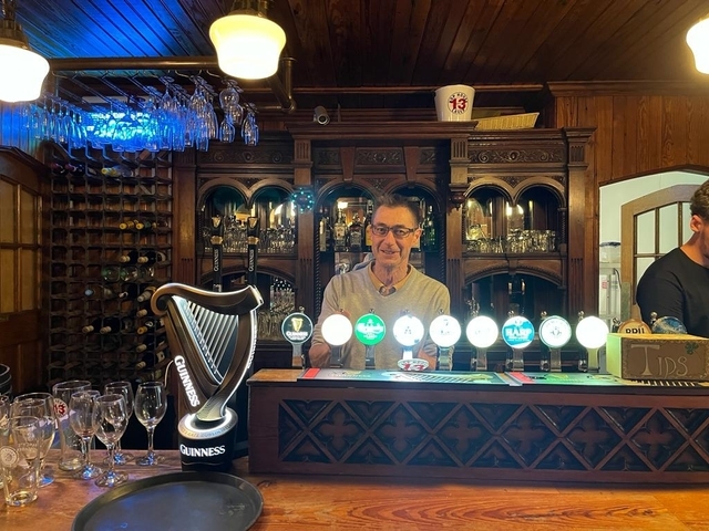       Bartender behind a bar with illuminated taps.
  
