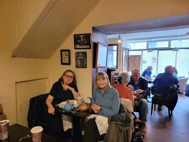       People sitting at tables inside a cozy cafe.
  