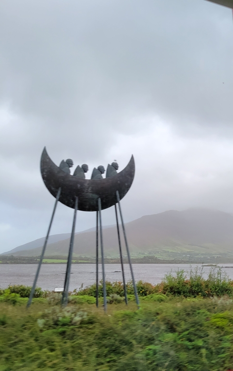       Abstract sculpture of people in a crescent shape.
  