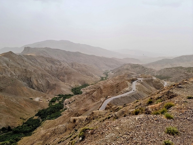 Rugged Moroccan landscape with a winding road.