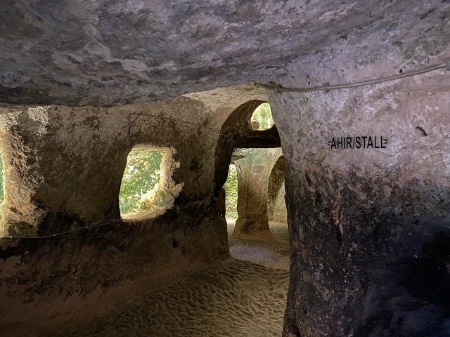       Cave interior with inscriptions and multiple entrances.
  