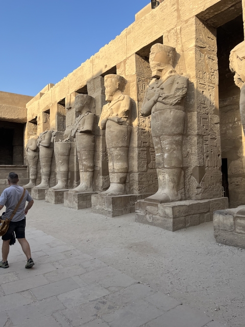       Man exploring ancient Egyptian structures with hieroglyphics.
  