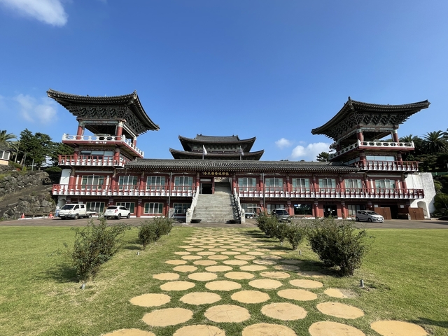       Traditional Korean building with twin towers under a clear sky.
  