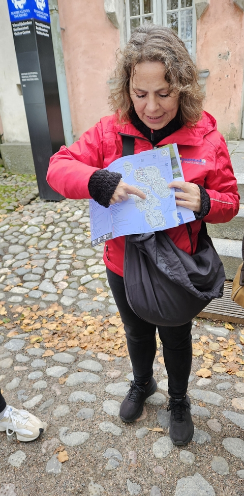 A person holding a map pointing at a location.