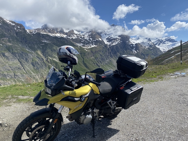       A motorcycle parked with snowy mountain views.
  