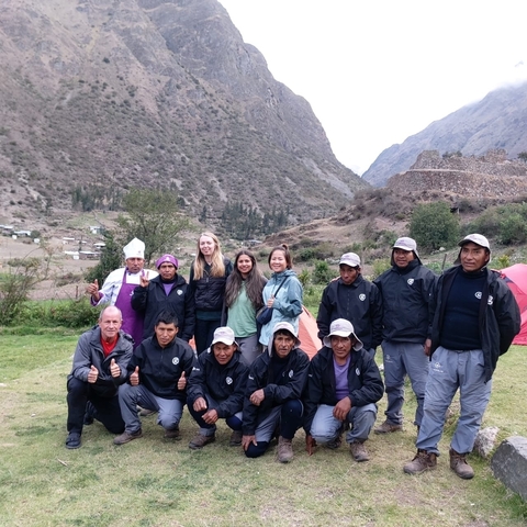       Group of hikers posing in a mountainous valley.
  