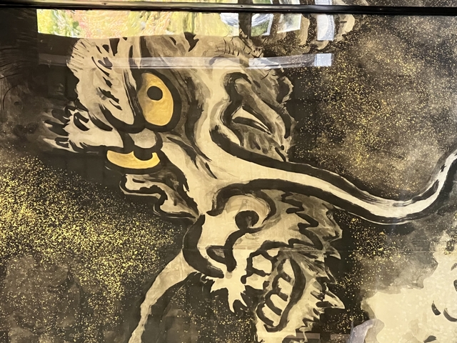       Decorative dragon illustration in black and gold.
  