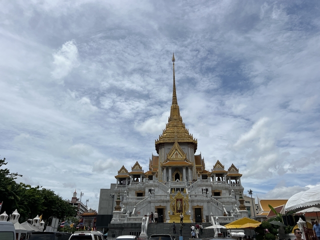 Large golden temple under a cloudy sky.