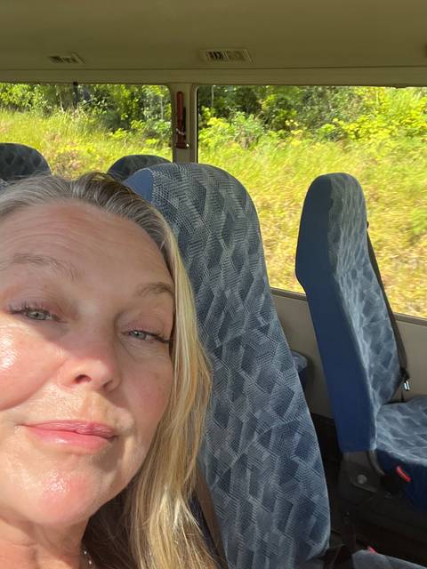       Person sitting inside a vehicle looking outside.
  