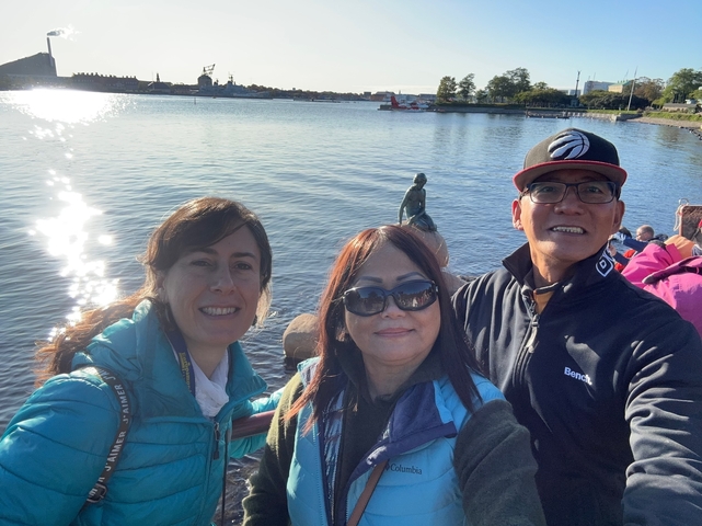 Group selfie in front of The Little Mermaid statue by the water.