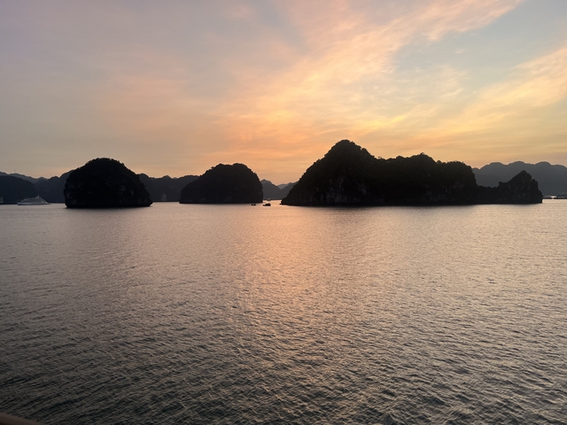       Scenic view of a bay at sunset with rock formations.
  