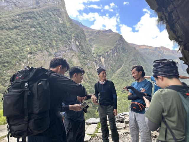       Group of hikers talking against a mountain backdrop.
  