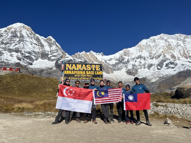       Group of people with flags at Annapurna Base Camp.
  