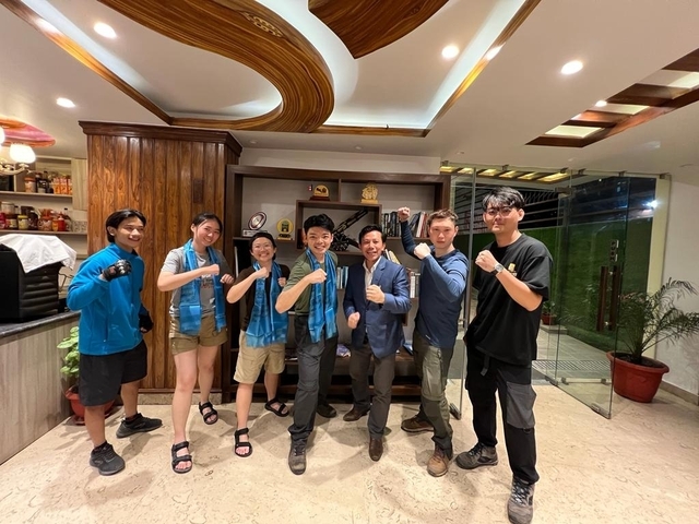       People posing indoors with a punch gesture.
  