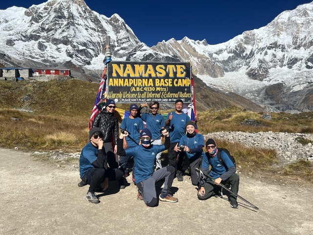       Group of hikers posing at Annapurna Base Camp.
  