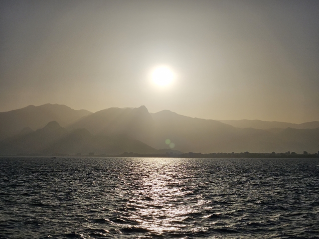      Sunset view over the sea and mountains.
  
