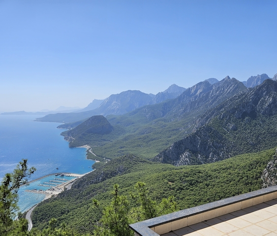       Scenic coastal view with a forested mountain landscape.
  
