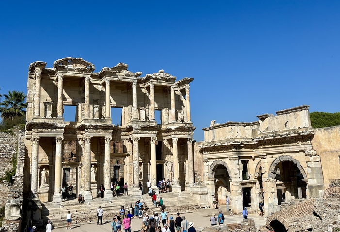       Ruins of an ancient library with tourists exploring.
  