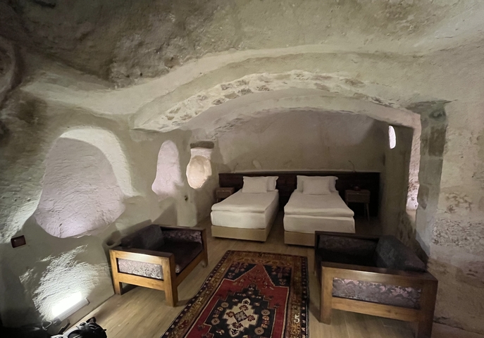       Cave hotel room with two beds and traditional decor.
  