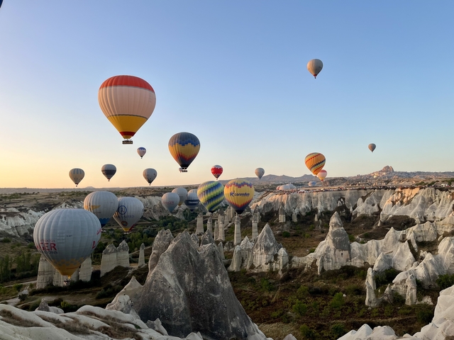       Hot air balloons soaring above a rocky landscape
  