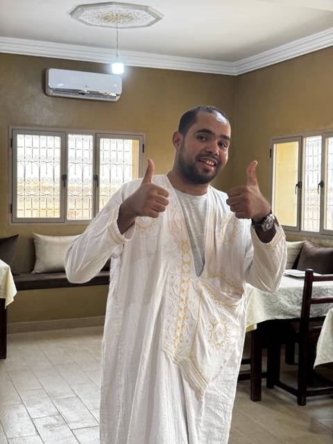 Man in traditional attire smiling.
