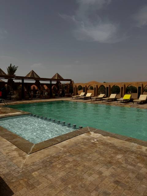       Swimming pool with a view of desert architecture.
  