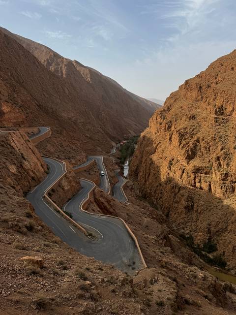       Winding desert road along rock formations.
  