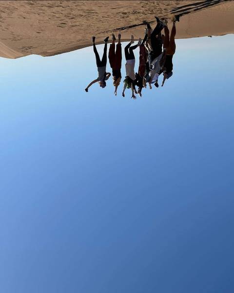 A group of people with raised arms in the desert.