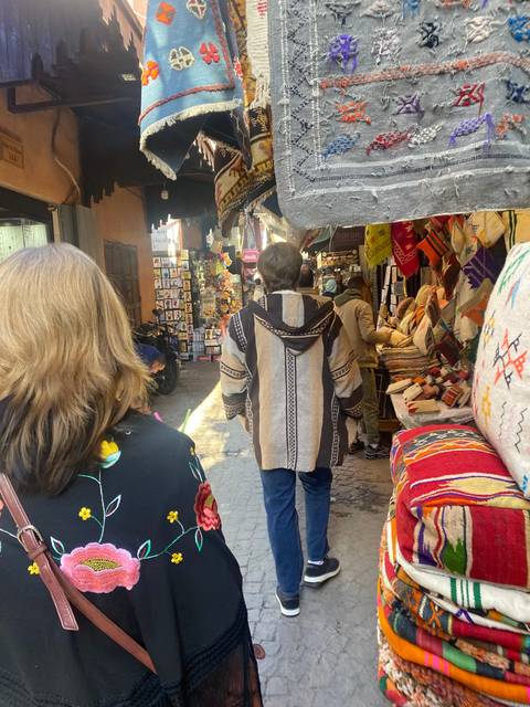 Crowded market with textiles and shoppers.