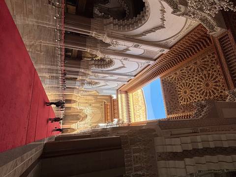 Interior of ornate building with red carpet.