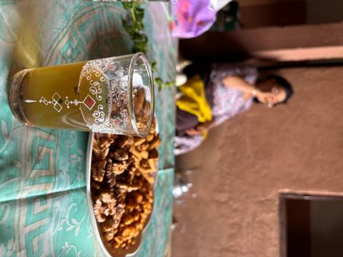 Cup of tea with snacks and a person in the background.