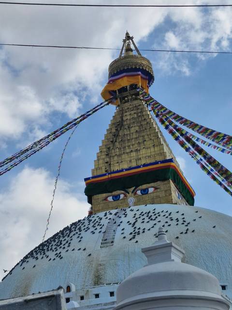 Stupa with prayer flags and eyes of Buddha.