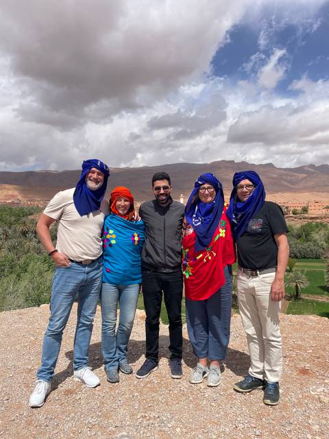Group of people wearing traditional clothing with a valley in the background.