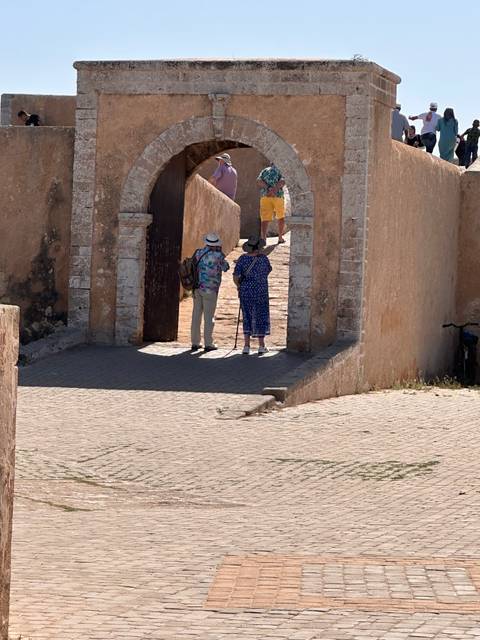 Tourists walking through an archway in a historic site.