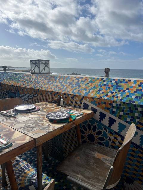       Table with colorful mosaic tiles and clouded sky.
  