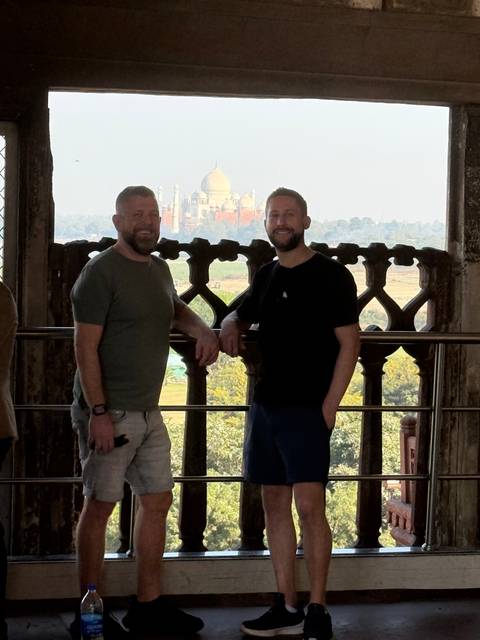 Two men with a monument in the distant background viewed from an indoor setting.