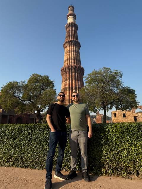 Two people with a towering historical structure in the background.