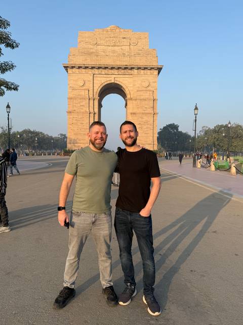 Two men in front of an archway structure.