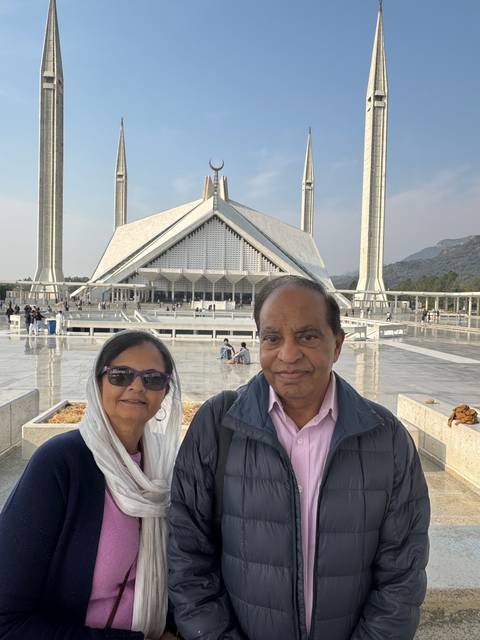 Couple standing in front of an iconic mosque with large minarets.