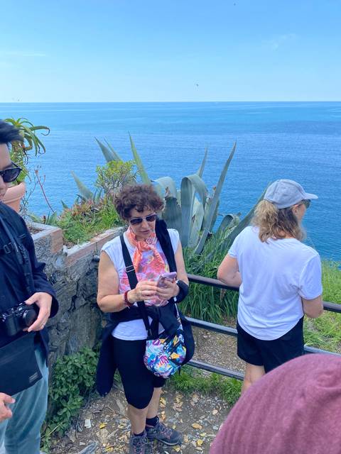Woman standing by a coastal walkway.