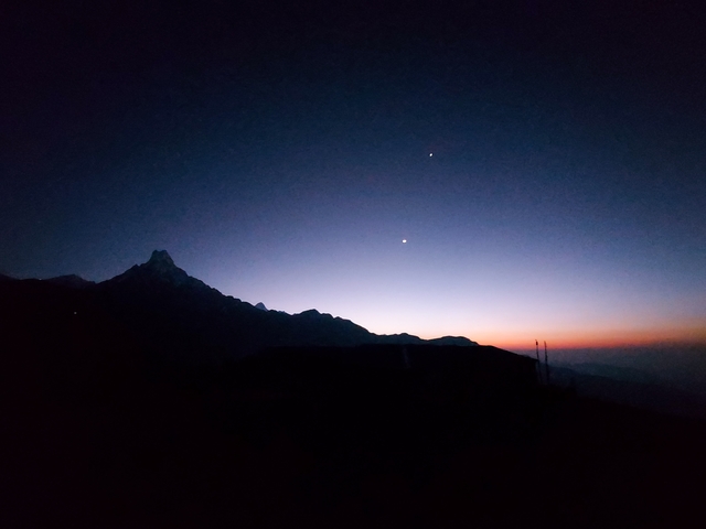 Silhouette of mountains with a starry sky at sunset.