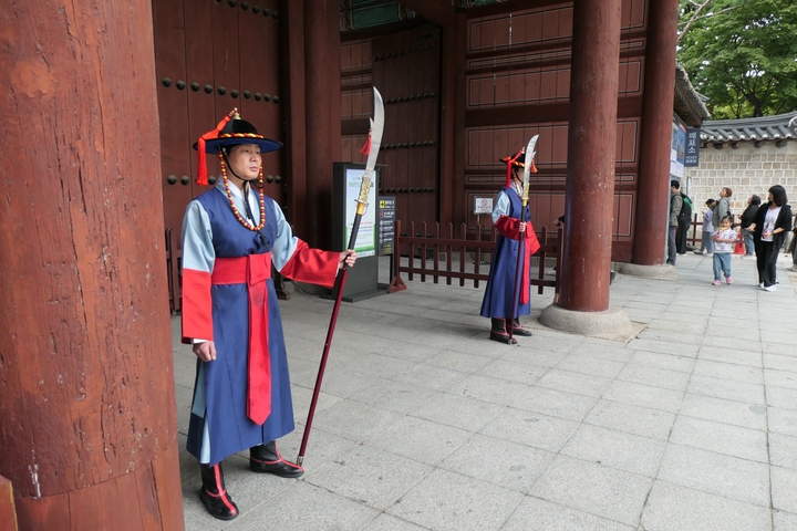 Guards in traditional costumes standing at a gate.