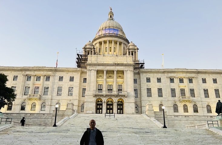 Man in front of a large classical building with a dome.