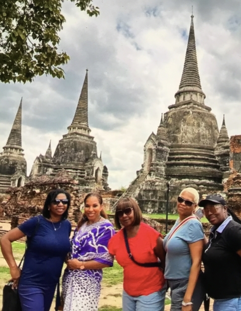 Group in front of ancient temple ruins with pointed stupas.