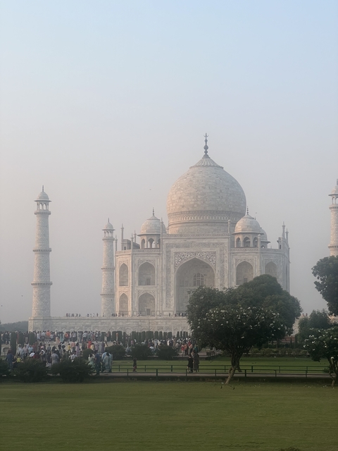       Iconic white marble mausoleum under a hazy sky.
  