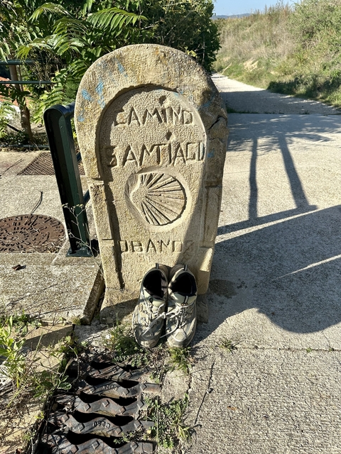 Pilgrim's milestone with hiking boots.