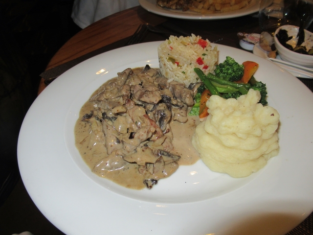       A plated dish with mashed potatoes, vegetables, and meat in a creamy sauce.
  