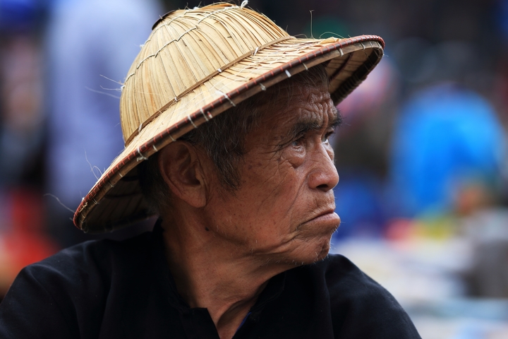 Portrait of a man in traditional hat looking sideways.